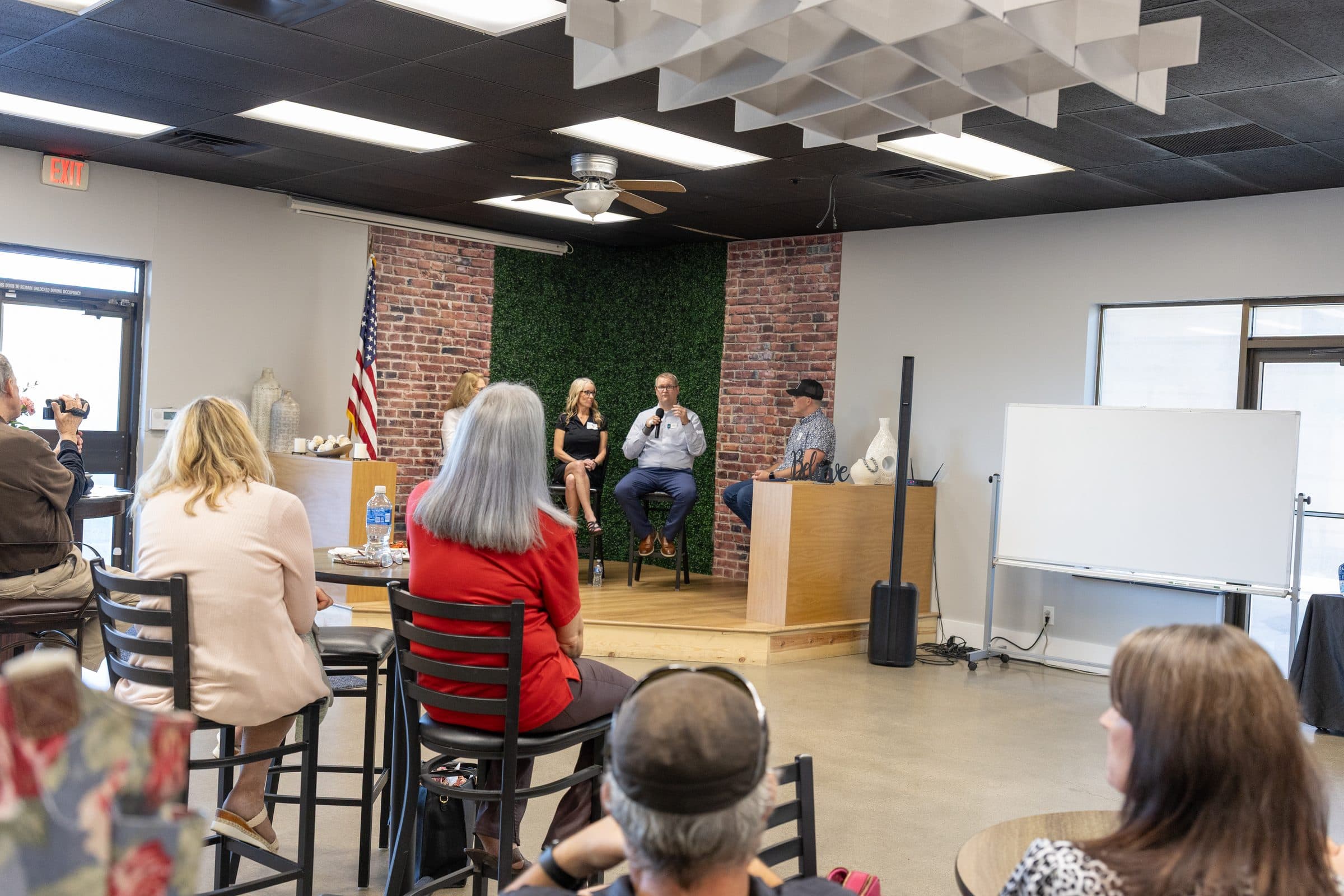 A full room of Kansas City professionals and the panel at a New Life Networking event — real local-event scale